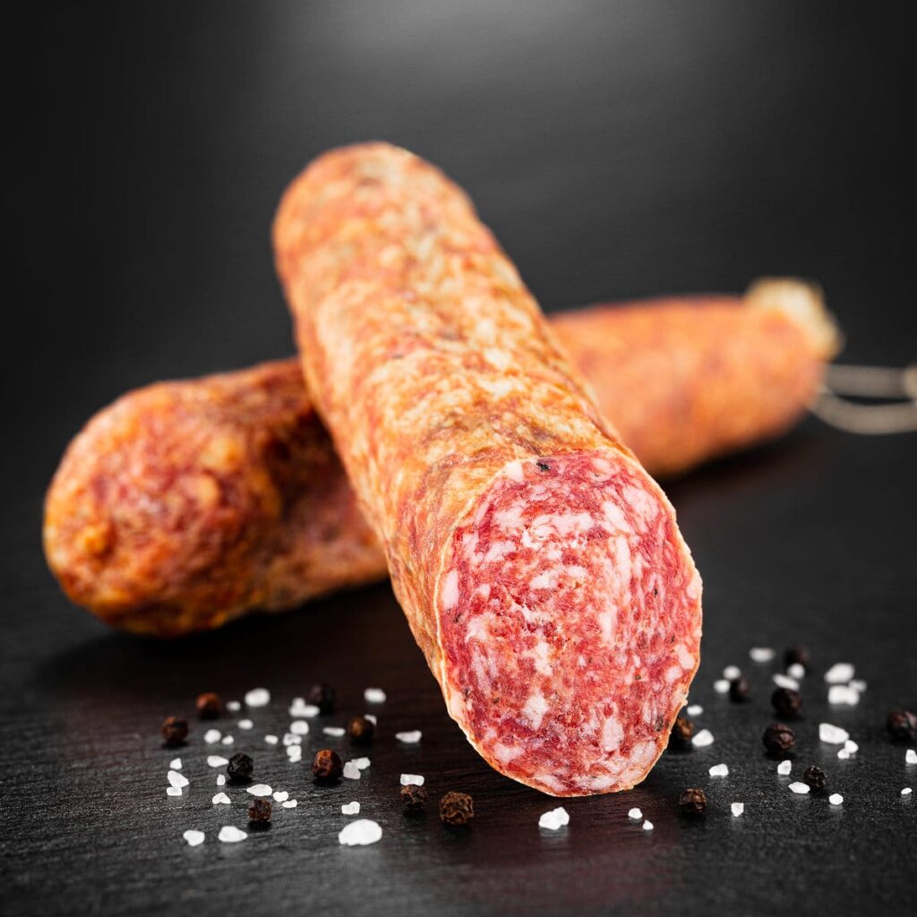 Stracke dick luftgetrocknet und geräuchert angerichtet auf Schwarzem Untergrund.